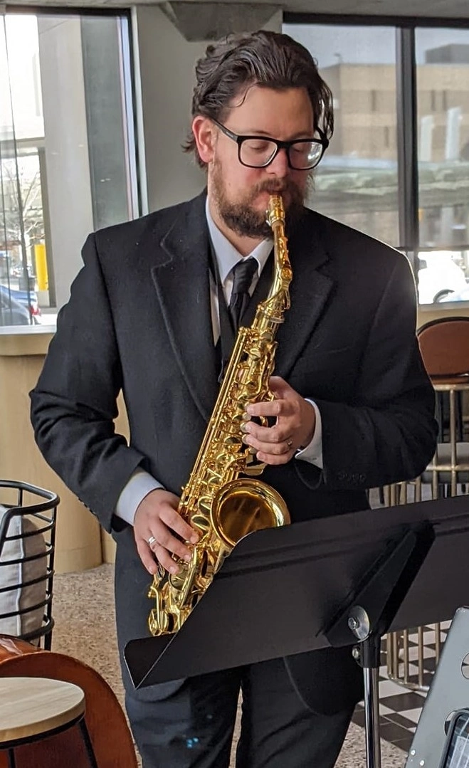 man playing saxophone during live music performance indoors